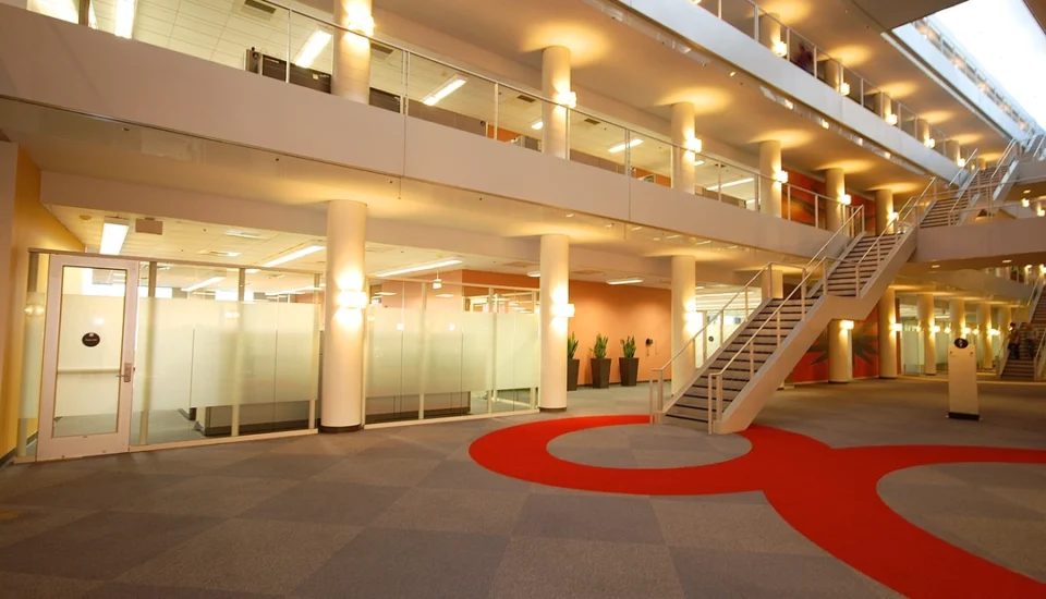 interior of a modern office building or a corporate lobby, possibly featuring multiple floors and open workspaces