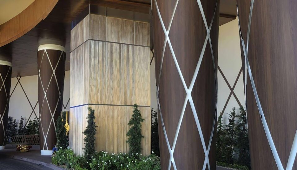 Modern woodgrain column wrap by Engineered Group in corporate office lobby.